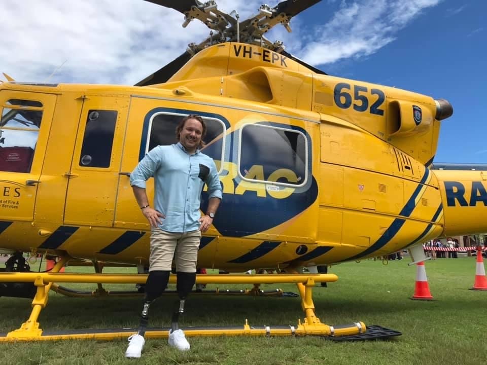 Rob Pike beside an RAC rescue helicopter